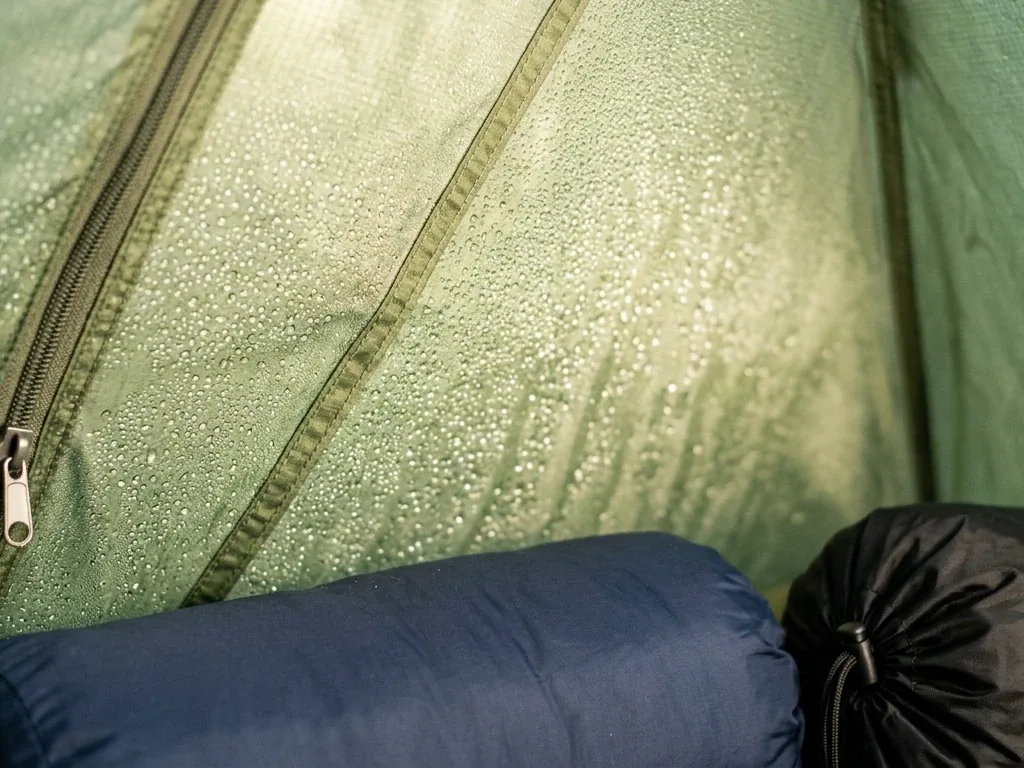 Nahaufnahme einer Zeltinnenwand mit feinen Kondenswassertropfen im weichen Morgenlicht