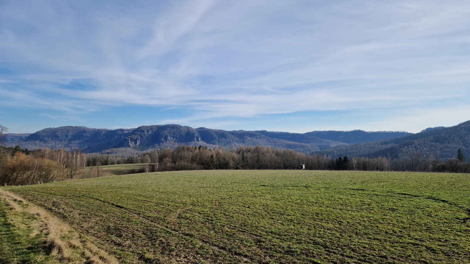 Feld- und Hügellandschaft bei Bad Schandau im späten Nachmittagslicht, Elbsandsteingebirge im Hintergrund
