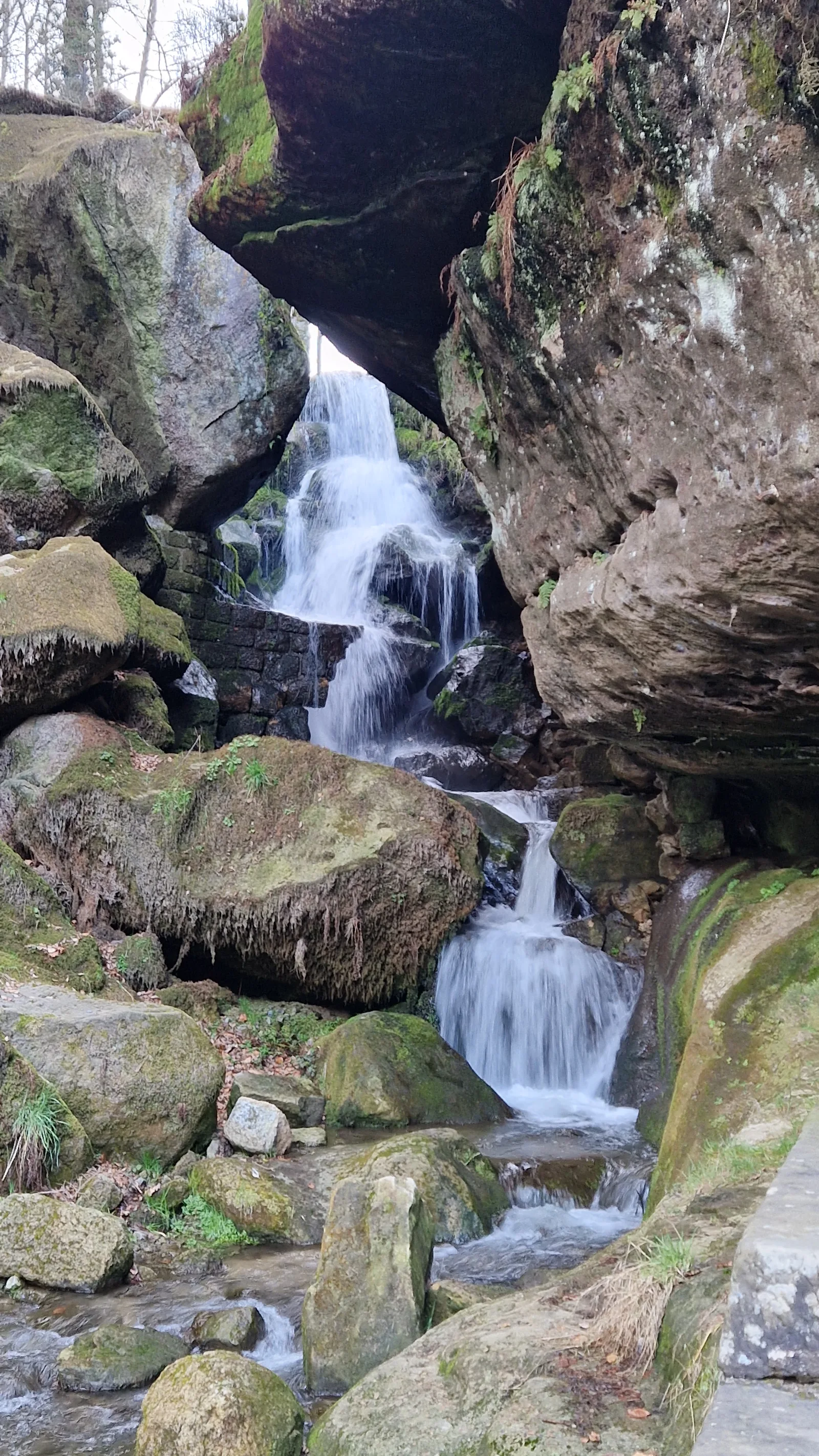 Wasserfall und kleiner Mühlgraben mit moosbewachsenen Steinstufen