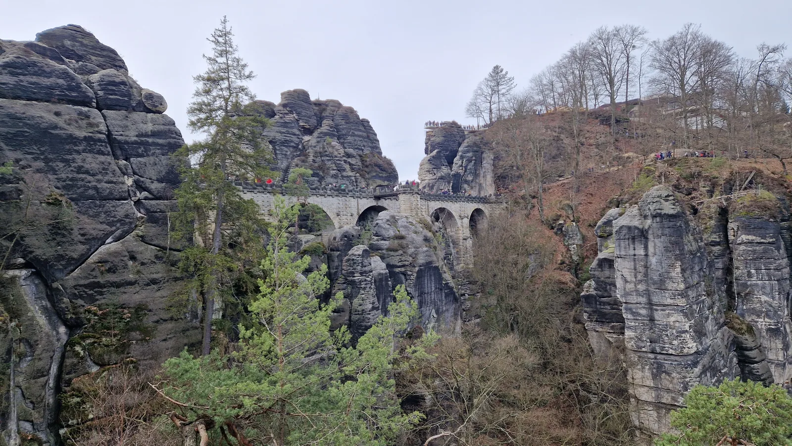 Die Basteibrücke im Elbsandsteingebirge verbindet einzelne Sandsteinfelsen, Blick über die bewaldete Schlucht
