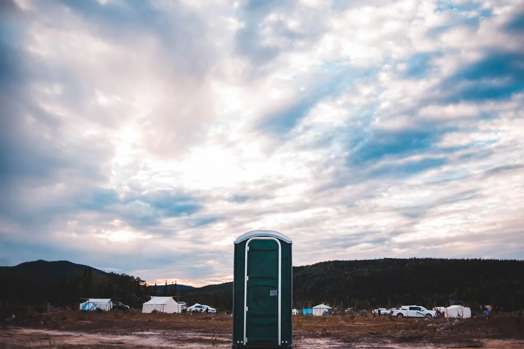 blue and white portable bathroom under white and blue sky