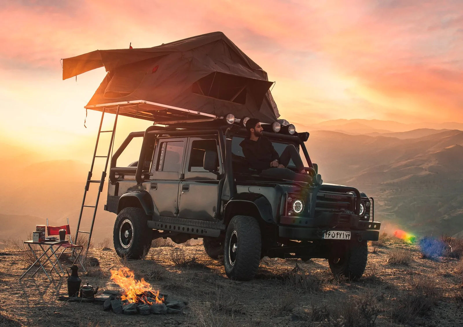 Aufgeklapptes Auto-Dachzelt auf einem SUV an einem Bergcampingplatz