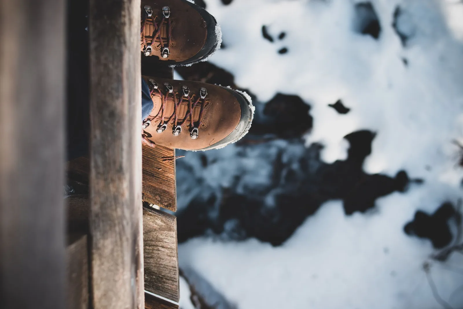 Nahaufnahme von Wanderschuhen und Wollsocken beim Einlaufen auf einer Terrasse