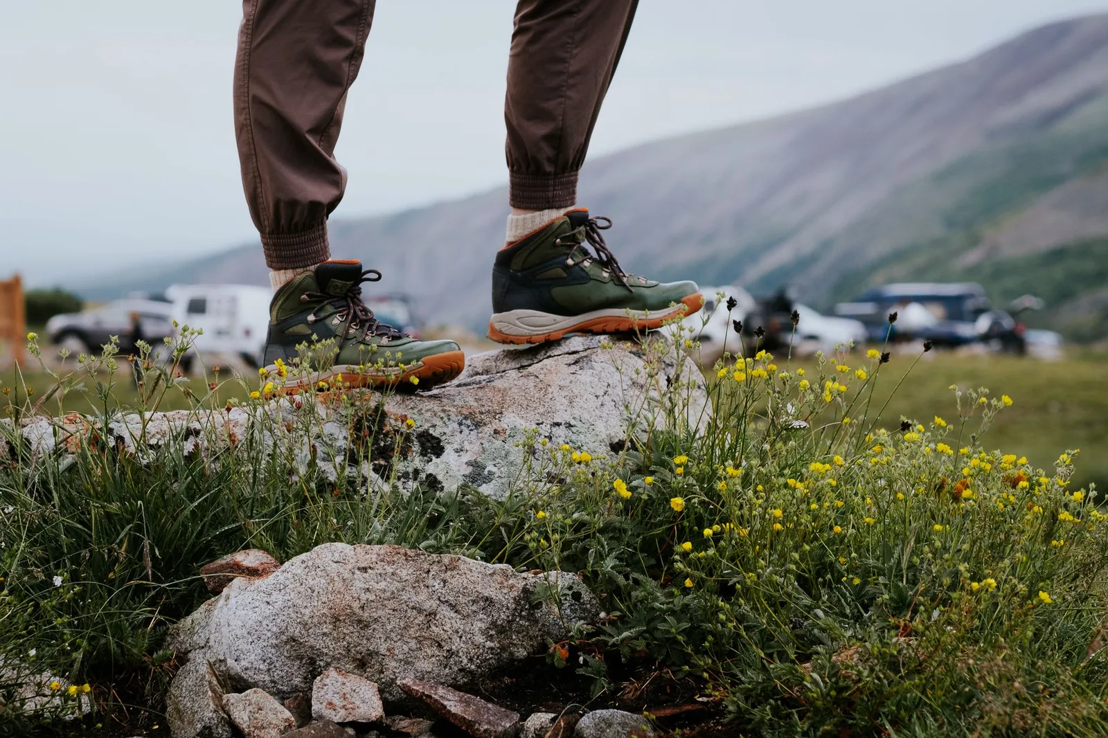 Paar robuste Wanderschuhe mit Profilsohle auf einem steinigen Bergwanderweg