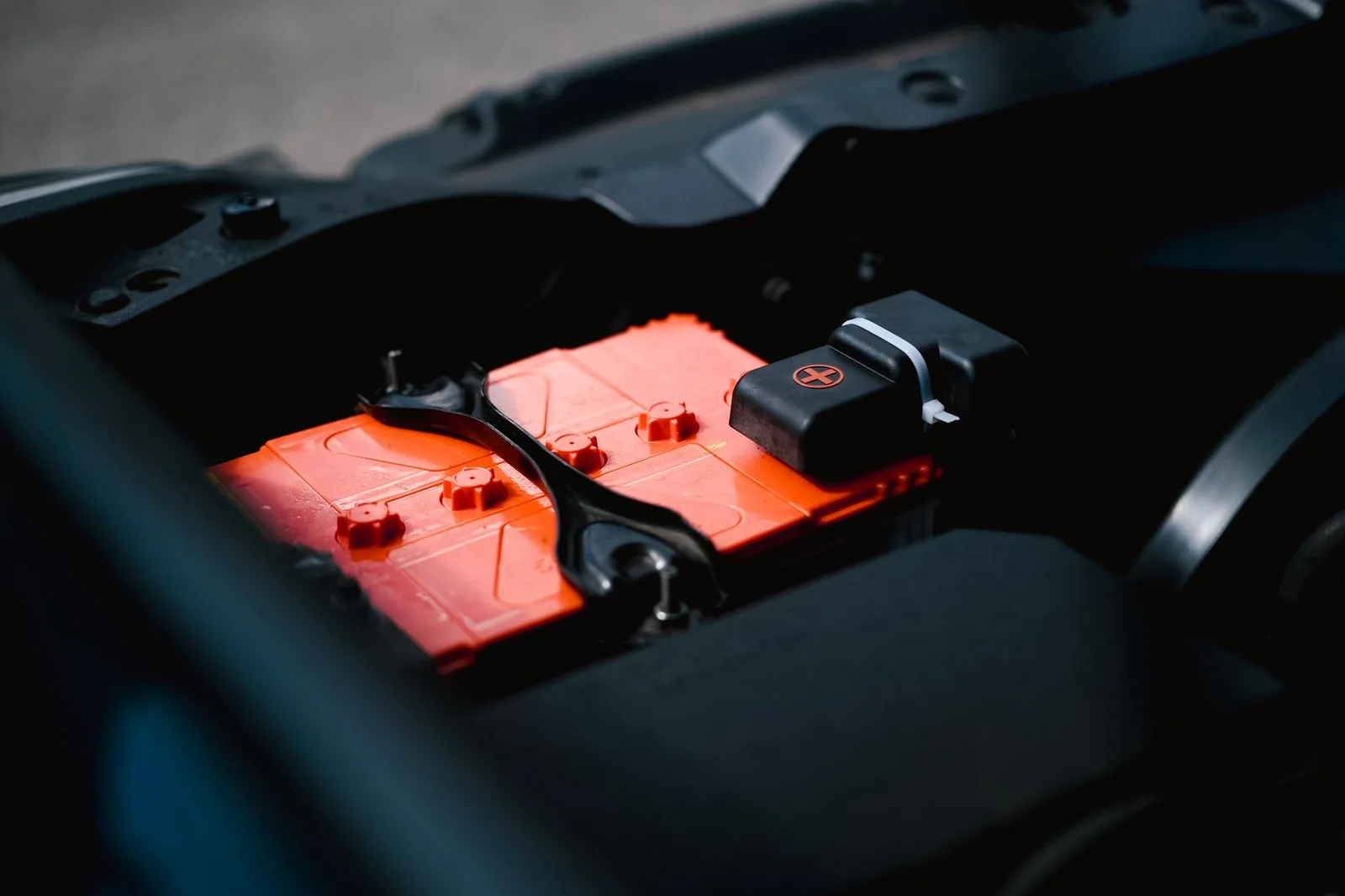 Nahaufnahme: Hände schließen ein Ladekabel an eine Wohnmobil-Bordbatterie an, winterliche Umgebung mit Reifbildung sichtbar